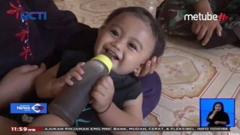 Café-amante de la base: en Indonesia, una madre le da a un bebé de un año de edad café en lugar de leche