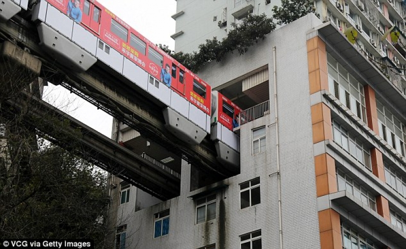 En China, un tren pasa a través de un edificio residencial
