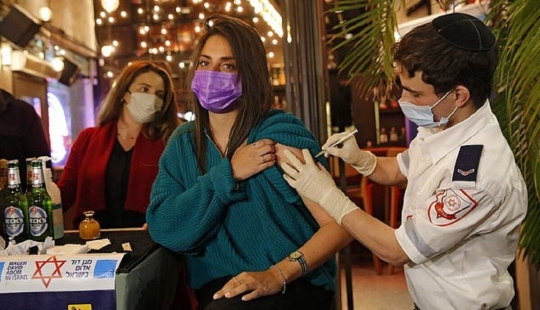 En un bar de la liberación de Israel verter los que están vacunados contra el coronavirus En un bar de la liberación de Israel verter los que están vacunados contra el coronavirus