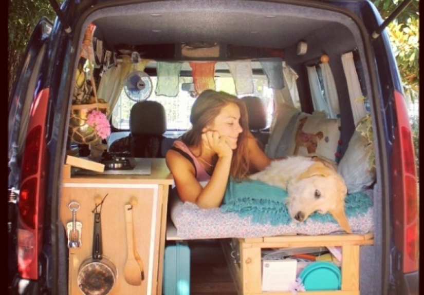The girl has converted an old van into a motorhome and travels the world with his dog The girl has converted an old van into a motorhome and travels the world with his dog