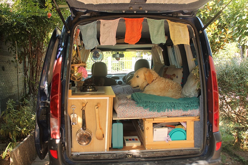 The girl has converted an old van into a motorhome and travels the world with his dog The girl has converted an old van into a motorhome and travels the world with his dog