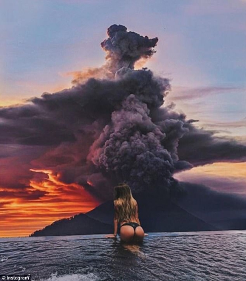 Mientras los residentes de Bali se alejan del volcán, los turistas son fotografiados con el telón de fondo de las emisiones de cenizas Mientras los residentes de Bali se alejan del volcán, los turistas son fotografiados con el telón de fondo de las emisiones de cenizas