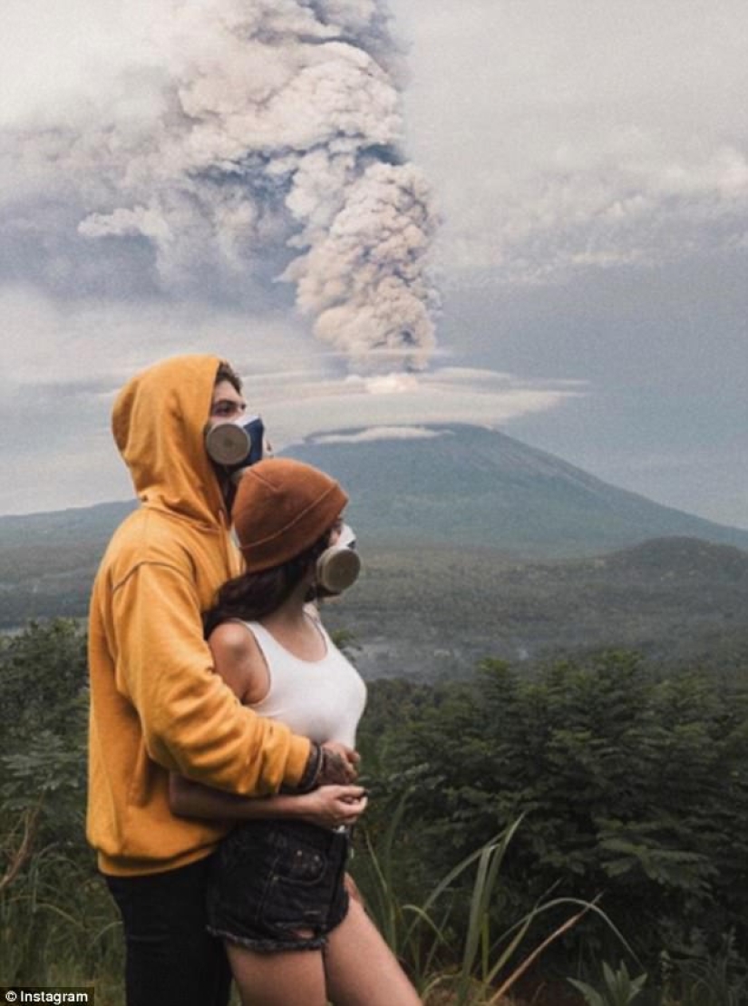 Mientras los residentes de Bali se alejan del volcán, los turistas son fotografiados con el telón de fondo de las emisiones de cenizas Mientras los residentes de Bali se alejan del volcán, los turistas son fotografiados con el telón de fondo de las emisiones de cenizas