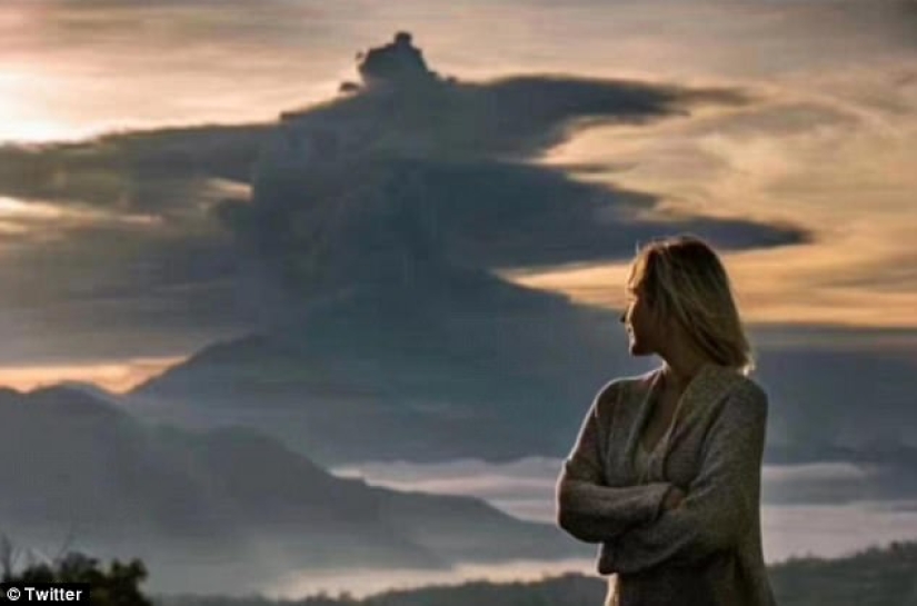 Mientras los residentes de Bali se alejan del volcán, los turistas son fotografiados con el telón de fondo de las emisiones de cenizas Mientras los residentes de Bali se alejan del volcán, los turistas son fotografiados con el telón de fondo de las emisiones de cenizas