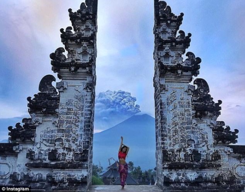 Mientras los residentes de Bali se alejan del volcán, los turistas son fotografiados con el telón de fondo de las emisiones de cenizas Mientras los residentes de Bali se alejan del volcán, los turistas son fotografiados con el telón de fondo de las emisiones de cenizas