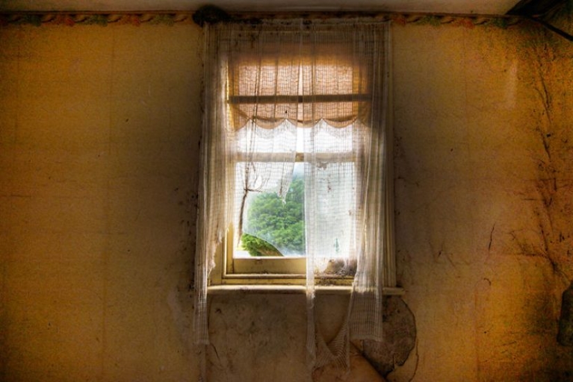Photographer taking pictures of windows in abandoned places