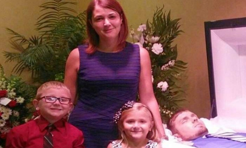 That's why this woman with children is smiling near her husband's coffin