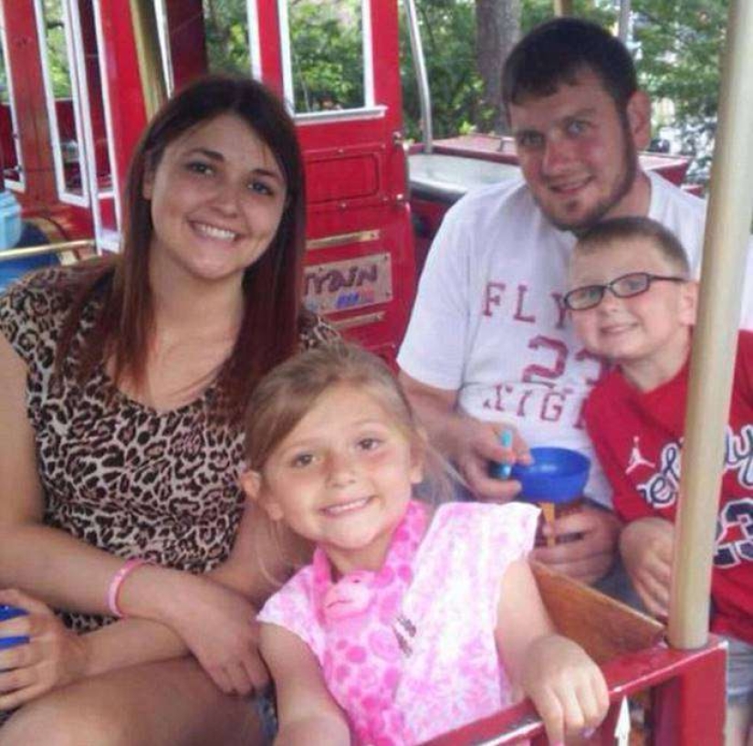 That's why this woman with children is smiling near her husband's coffin