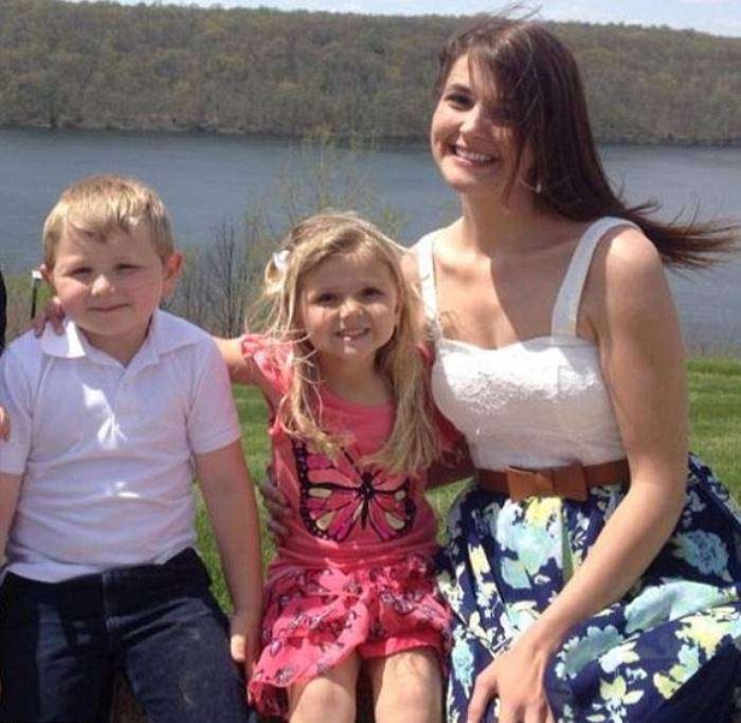 That's why this woman with children is smiling near her husband's coffin