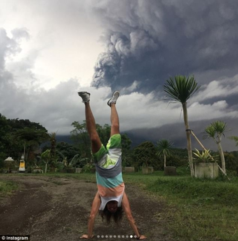 While the residents of Bali are moving away from the volcano, tourists are photographed against the background of ash emissions