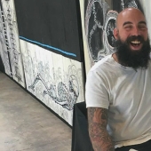 A hole with a surprise: the master offers to make people a tattoo for free if they put their hand in the hole