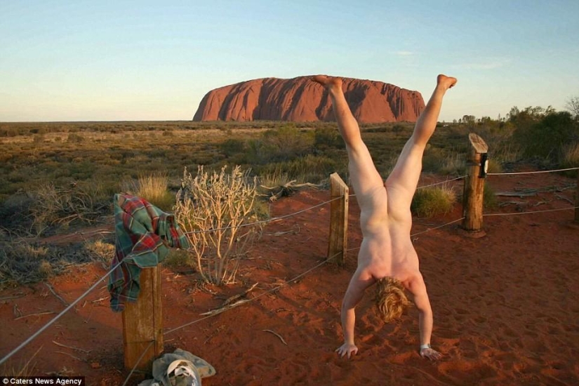 An exhibitionist traveler takes a naked photo against the backdrop of nature and city attractions