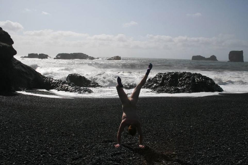 An exhibitionist traveler takes a naked photo against the backdrop of nature and city attractions