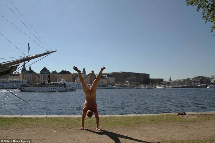 An exhibitionist traveler takes a naked photo against the backdrop of nature and city attractions
