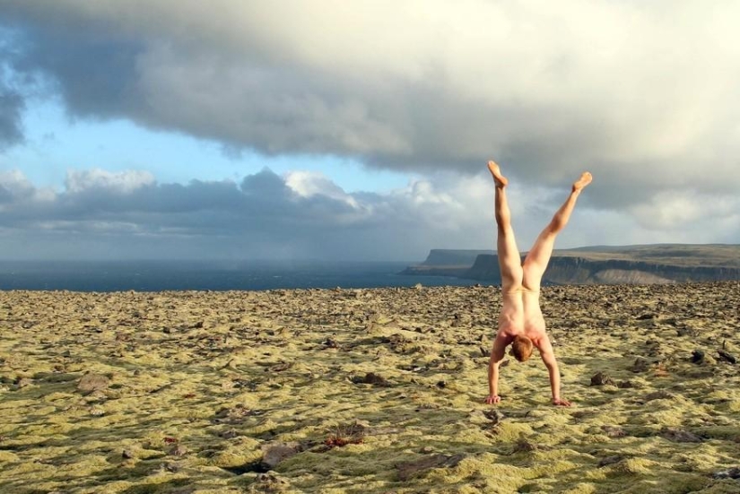 An exhibitionist traveler takes a naked photo against the backdrop of nature and city attractions