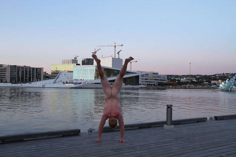 An exhibitionist traveler takes a naked photo against the backdrop of nature and city attractions