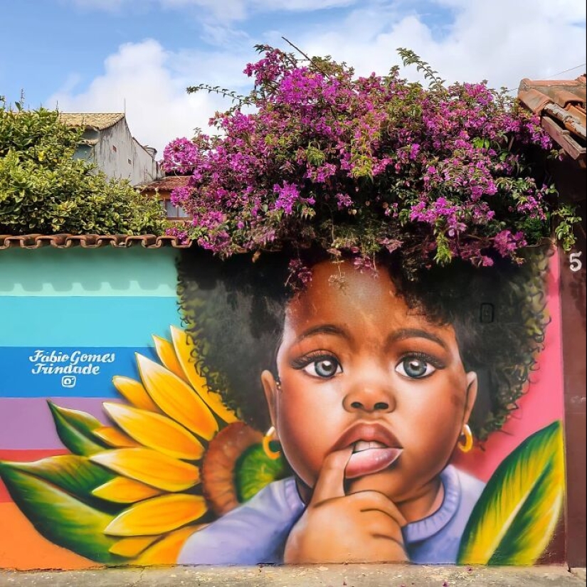 Artista callejero continúa pintando retratos en paredes junto a árboles que también sirven como cabello