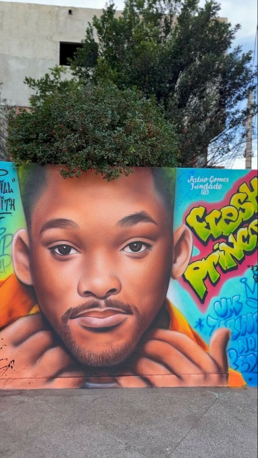 Artista callejero continúa pintando retratos en paredes junto a árboles que también sirven como cabello