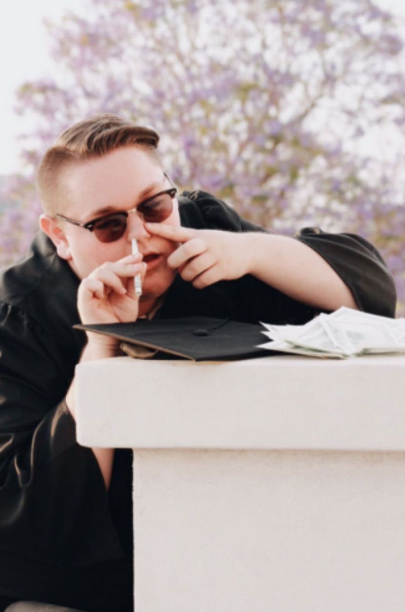 La sesión de fotos de graduación de este estudiante fue claramente un éxito.