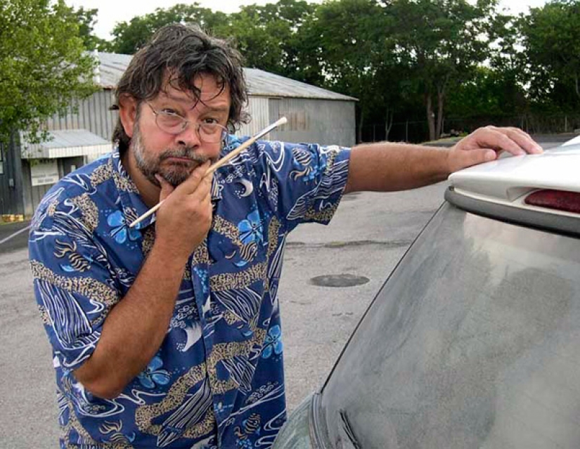 Trabajo polvoriento: el artista pinta pinturas geniales en ventanas sucias de automóviles Trabajo polvoriento: el artista pinta pinturas geniales en ventanas sucias de automóviles