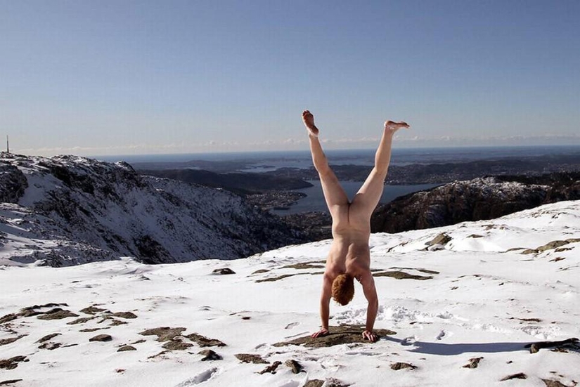Un viajero exhibicionista se toma una foto desnuda con el telón de fondo de la naturaleza y las atracciones de la ciudad.