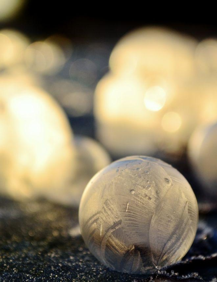 Bolas de cristal - una niña fotografía pompas de jabón en el frío
