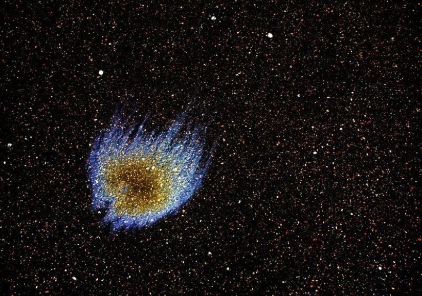 Galaxias y constelaciones ilusorias hechas de gasolina y aceite sobre asfalto