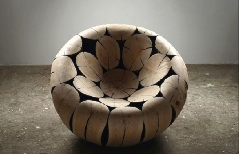 There is grass in the yard, firewood on the grass