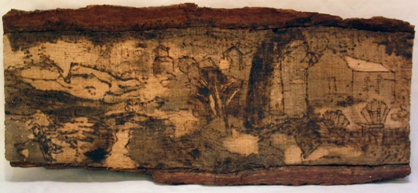 There is grass in the yard, firewood on the grass